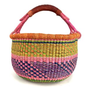Angled view of the medium round Bolga basket showing an orange rim and fleck band with a pink-and-navy diamond pattern below