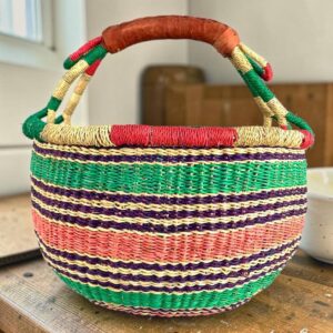 Medium round Bolga basket with a natural-and-red rim with green, purple and coral horizontal stripes, leather handles
