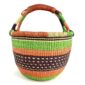 Angled view of the medium round Bolga basket showing an orange-and-cream rim with green, orange and plum bands, the plum band with cream dot detail