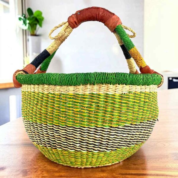 Fresh-toned banded medium round Bolga basket with leather-wrapped handle, on a timber table