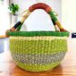 Fresh-toned banded medium round Bolga basket with leather-wrapped handle, on a timber table