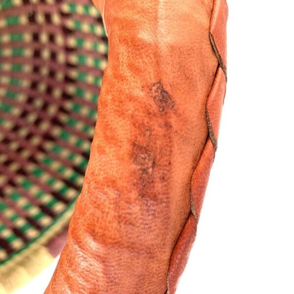 medium-round-basket-687-blossom-rich-tone-checked-bolga-african-basket-bashiri-4 Close-up of the minor scuff on the leather handle