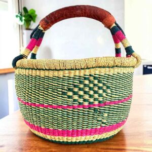 Two-tone diamond-pattern medium round Bolga basket with leather-wrapped handle, on a timber table