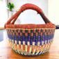 Warm-toned zigzag medium round Bolga basket with leather-wrapped handle, on a timber table