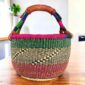 Rich-toned zigzag medium round Bolga basket with leather-wrapped handle, on a timber table
