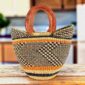 Mini market basket with a dark zigzag pattern on a natural weave and leather-wrapped handles