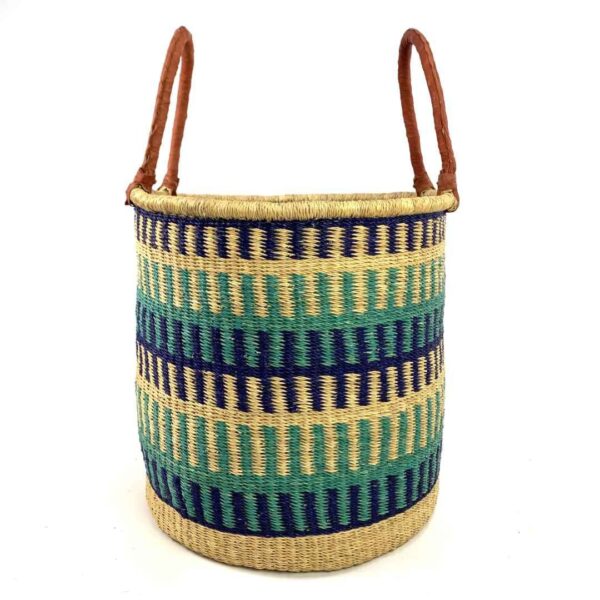 open-laundry-basket-115-wishywashy-blue-green-african-bashiri-3 Front view of the open laundry basket with navy, teal and green bands on natural straw and tall leather handles on a white background
