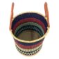 Angled view of the open laundry basket with navy and red bands with a pale green check and tall leather handles