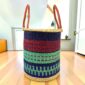 Open laundry basket with navy, red and mint green bands and tall leather handles