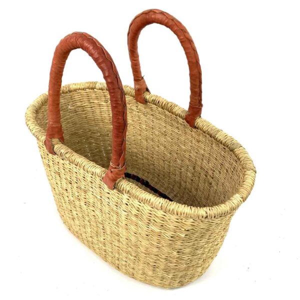 oval-basket-475-bottomless-natural-african-woven-bashiri-2 Angled view of the oval Bolga basket with natural undyed straw, showing the woven interior