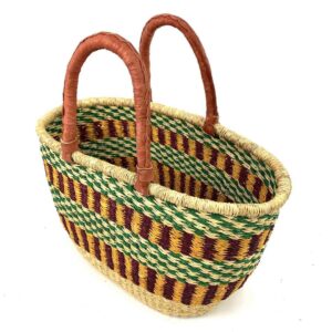 Angled view of the oval Bolga basket with a green checkered band over maroon and gold stripes, showing the woven interior