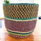 Vegan planter basket with jewel-tone checked bands, on a timber table