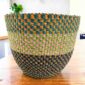 Vegan planter basket woven in three tiers of checked, muted and deep tones, on a timber table