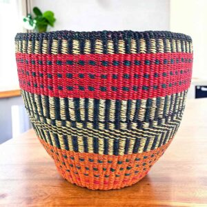 Vegan planter basket with bold high-contrast stripes and a warm base, on a timber table
