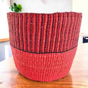 Vegan planter basket in two warm shades, ribbed above a smooth base, on a timber table