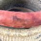 Close-up of the stain on the leather handle of the black and natural Bolga pot basket