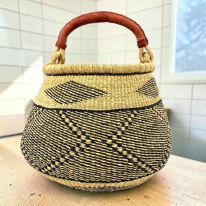 Bolga pot basket with a black and natural zigzag and diamond pattern and a leather-wrapped handle