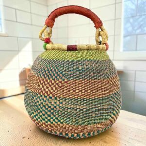 Bolga pot basket with soft teal, peach and green stripes and a leather-wrapped handle