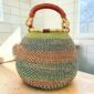 Bolga pot basket with soft teal, peach and green stripes and a leather-wrapped handle