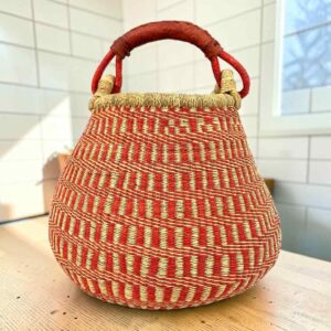 Bolga pot basket with an orange-red and natural stepped pattern and a leather-wrapped handle