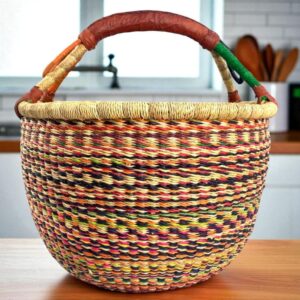 Front view of a large round Bolga basket, handwoven from elephant grass with a sturdy leather handle