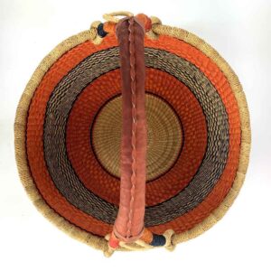 Top-down view inside the orange and black xl round bolga basket, showing the coiled base