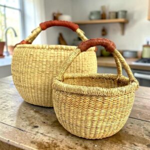 Round bolga basket set in natural straw, a small and large basket with leather-wrapped handles