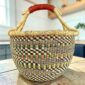 Large round Bolga basket in a muted colourway, leather handles