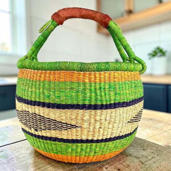 Large round Bolga basket with bright blocks of colour, leather handles