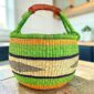 Large round Bolga basket with bright blocks of colour, leather handles
