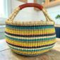 Large round Bolga basket with a bold striped pattern, leather handles