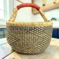 Large round Bolga basket with natural straw and deep inky fine checks, leather-wrapped handle, on a timber benchtop