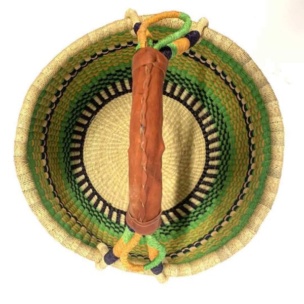 round-large-basket-863-thrive-green-navy-woven-bolga-bashiri-2 Top-down view inside the large round Bolga basket with fresh leafy tones and a band of deep inky checks, showing the coiled base and leather handle