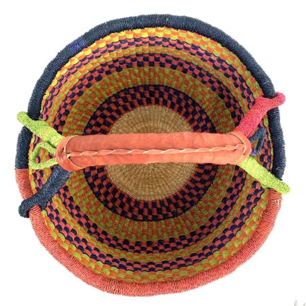 round-large-basket-864-wonder-orange-navy-lime-bolga-woven-bashiri-2 Top-down view inside the large round Bolga basket with bright citrus and rosy bands with deep inky checks, showing the coiled base and leather handle