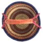 Top-down view inside the large round Bolga basket with an inky rim over rust and amber patterning, showing the coiled base and leather handle