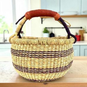 Small round Bolga basket with deep-toned stripes on a natural weave and leather-wrapped handle