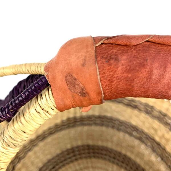 small-round-african-basket-703-akua-bashiri-4 Close-up of the scuffing on the leather handle of the small round Bolga basket