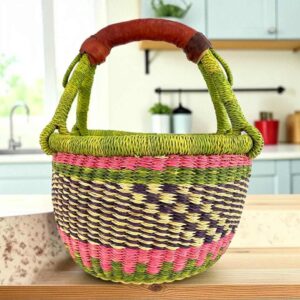 Small round Bolga basket with a chequered body and bright handle wraps and leather-wrapped handle
