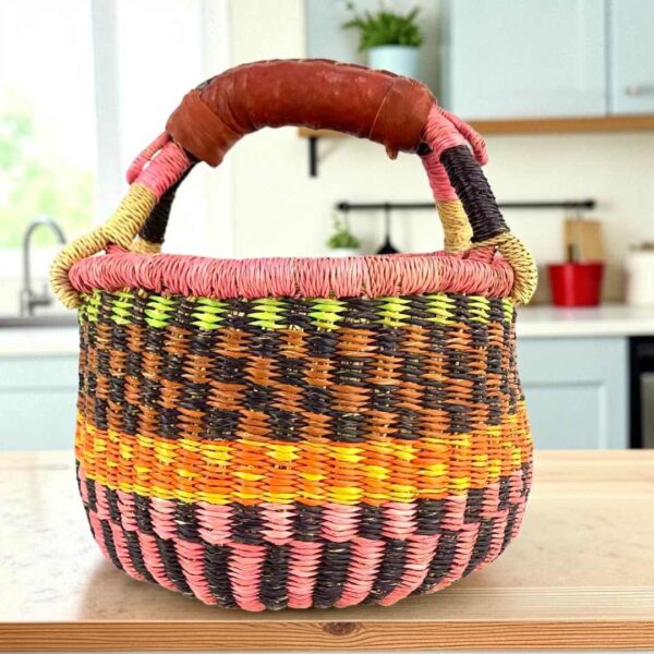 small-round-african-basket-711-ama-bashiri Small round Bolga basket with bold chequered bands in warm tones and leather-wrapped handle