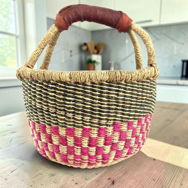 Handcrafted small round Bolga basket with reinforced leather handles and durable construction.