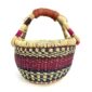 Front view of the small round Bolga basket with pink and navy bands on natural straw, on a white background