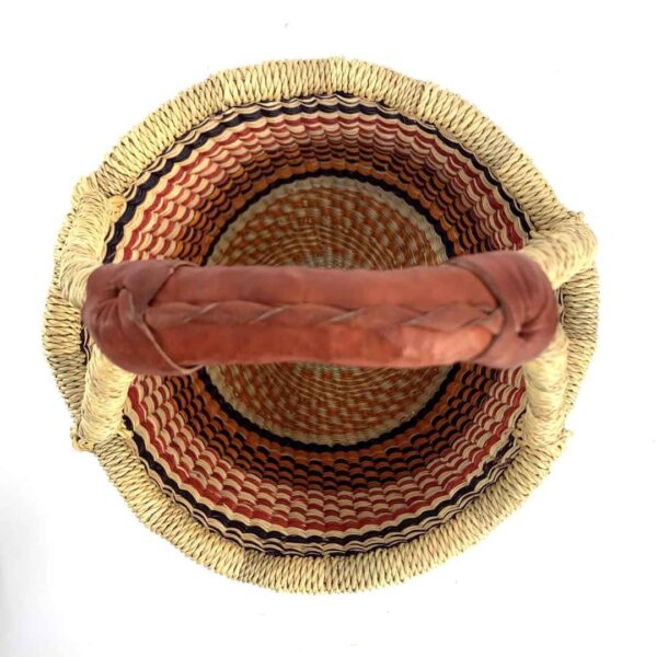 small-round-basket-717-spirals-orange-navy-woven-bolga-bashiri-2 Top-down view inside the small round Bolga basket with orange, red and navy stacked bands, showing the coiled base