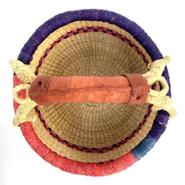 small-round-basket-731-downstream-red-purple-bolga-african-basket-bashiri-2 Top-down view inside the small round Bolga basket with red and purple checked bands on natural straw, showing the coiled base