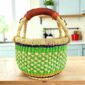 Small round Bolga basket with a chequered body in fresh, bright tones and leather-wrapped handle