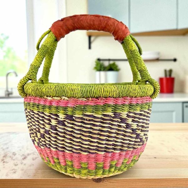 Small round Bolga basket with a diagonal pattern between bright bands and leather-wrapped handle