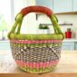 Small round Bolga basket with a diagonal pattern between bright bands and leather-wrapped handle