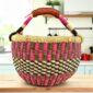 Small round Bolga basket with a checked pattern in warm, deep tones and leather-wrapped handle