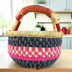 Small round Bolga basket with a bright chequered band framed in deep tones and leather-wrapped handle