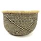 Front view of the round Bolga storage basket with a black and natural diagonal pattern and no handles on a white background