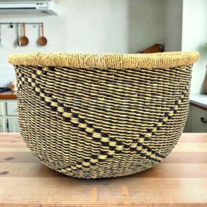 Round Bolga storage basket with a black and natural diagonal pattern and no handles